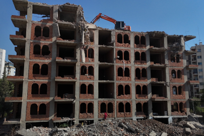 Adana’da 33 yıllık metruk bina, damına iş makinesi çıkartılarak yıkılıyor