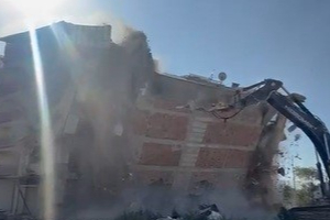 İş makinası üzerine doğru yıkılan 6 katlı binanın altında kalmaktan saniyelerle kurtuldu