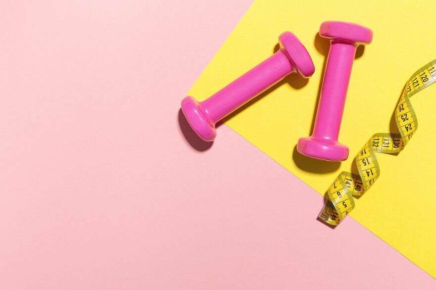 Dumbbells flat lay on pink and yello containing flat, lay, and gym